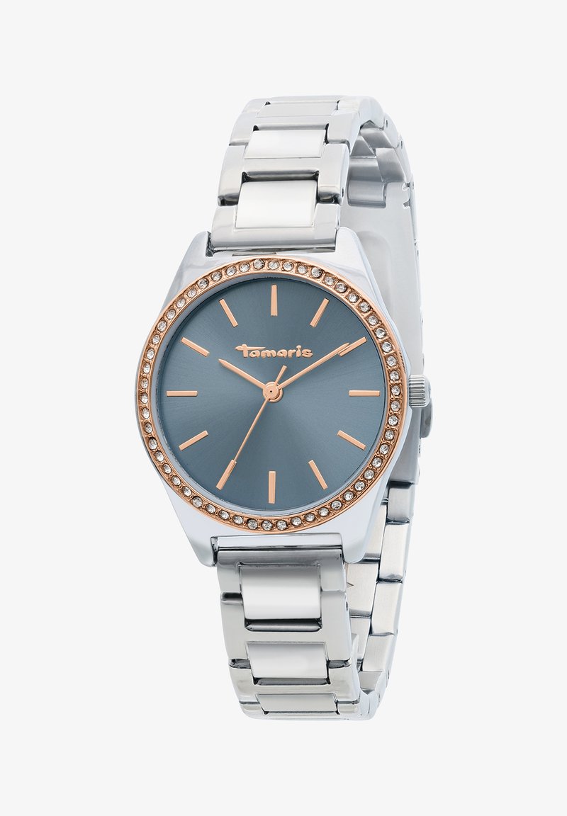 Montre-bracelet en métal argenté avec un cadran bleu, des index et aiguilles en or rose, une lunette ornée de cristaux, et le logo "Tamaris" sur le cadran.
