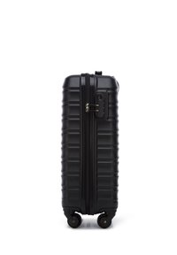 Black hardshell suitcase with a textured finish, zippered closure, combination lock, and four wheels for mobility.