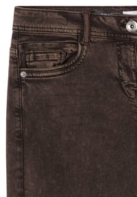 Gros plan sur un jean en denim marron montrant la ceinture, le bouton avant, le passant de ceinture, la poche avant principale et une petite poche à monnaie avec des détails de couture.