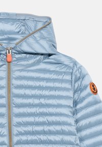 Γαλάζιο καπιτονέ μπουφάν με κουκούλα, κεντρικό φερμουάρ με πορτοκαλί τράβηγμα και στρογγυλό πορτοκαλί λογότυπο κηλίδας στο πάνω μανίκι.