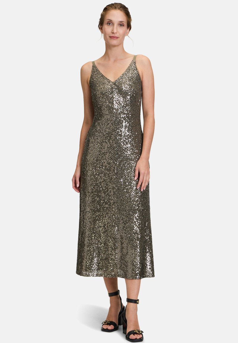 Robe de soirée en sequins avec un décolleté en V, des bretelles réglables et une longueur midi dans une teinte dorée métallique ; associée à des sandales noires à talons.