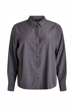 Tmavě šedá košile s dlouhým rukávem a zapínáním na knoflíky, s špičatým límcem a kovovými cvoky vpředu, zobrazená na bílém pozadí.