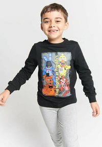 Black long-sleeve t-shirt featuring a colorful graphic of animated characters from "Five Nights at Freddy's," worn with gray pants.