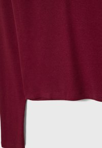 Bordeaux ribbelstof met een zachte textuur, voorzien van een rechte zoom en subtiele stiksels. Geschikt voor casual kleding.