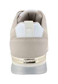 Sneaker beige con un retro liscio e imbottito, dettagli bianchi e un logo dorato metallico. Caratterizzata da una tomaia strutturata e una suola in gomma.
