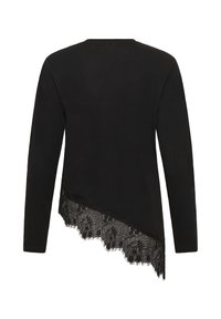 Haut noir à manches longues avec un ourlet asymétrique, orné d'une dentelle florale en bas. Vue de dos, partie supérieure unie.