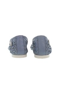 Jasnoniebieskie skórzane buty typu slip-on mają plecioną fakturę po bokach, srebrne akcenty oraz okrągły nos z białą podeszwą.