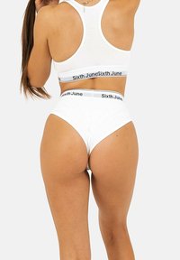 Top sportivo bianco e slip a vita alta con il marchio "Sixth June" stampato in nero sulle bande elastiche. Tessuto liscio e design aderente.