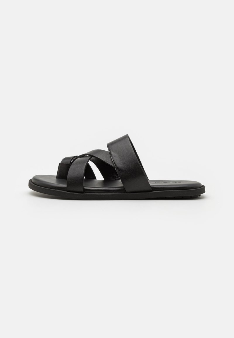 Fekete bőr csúszó szandál keresztbe tett pántokkal, lapos talppal és sima felülettel. Egyszerű design, minimális részletezéssel.
