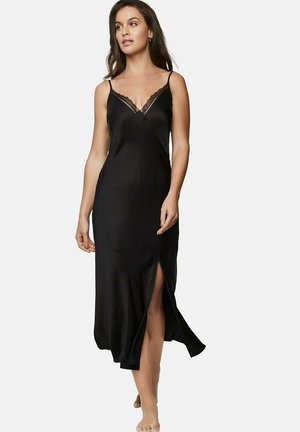 Robe nuisette en satin noir avec une finition en dentelle au niveau du col, présentant une silhouette fluide et une fente haute côté gauche.