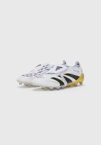 White football cleats with black and gold accents, mesh upper, textured sole, and purple studs. Features a striking design for optimal performance.