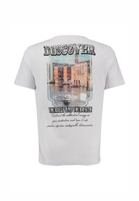 Camiseta de algodón blanca con un estampado en la parte posterior que presenta una escena colorida de un canal, la palabra "DESCUBRIR" y texto motivacional en negro y verde azulado.