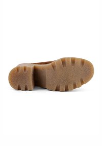 Brauner Gummischuhsohle mit strukturiertem Oberflächen, die ausgeprägte Profilmuster und ein solides, flaches Profil aufweist.