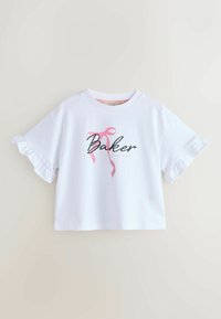 Valkoinen puuvillainen lyhythihainen crop-top, jossa on röyhelöhihat, musta teksti "Baker" ja edessä keskitetty vaaleanpunainen nauhakuva.