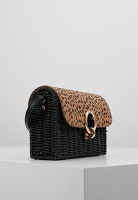 Sac à main noir en tissage avec un rabat brun à taches, des détails en métal doré et une forme structurée. Comprend une poignée et des matériaux texturés.