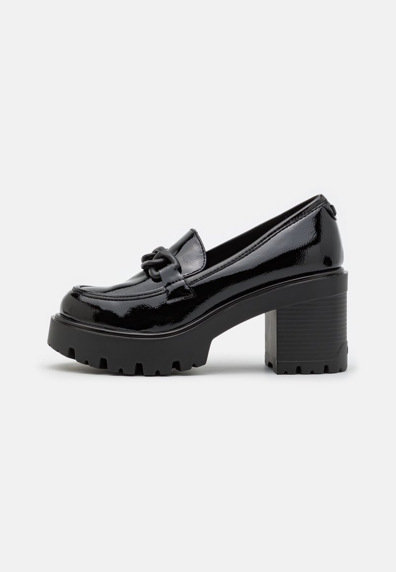Mocassin à talons en cuir verni noir avec une semelle plateforme épaisse, présentant un détail de nœud décoratif à l'avant et un talon bloc.
