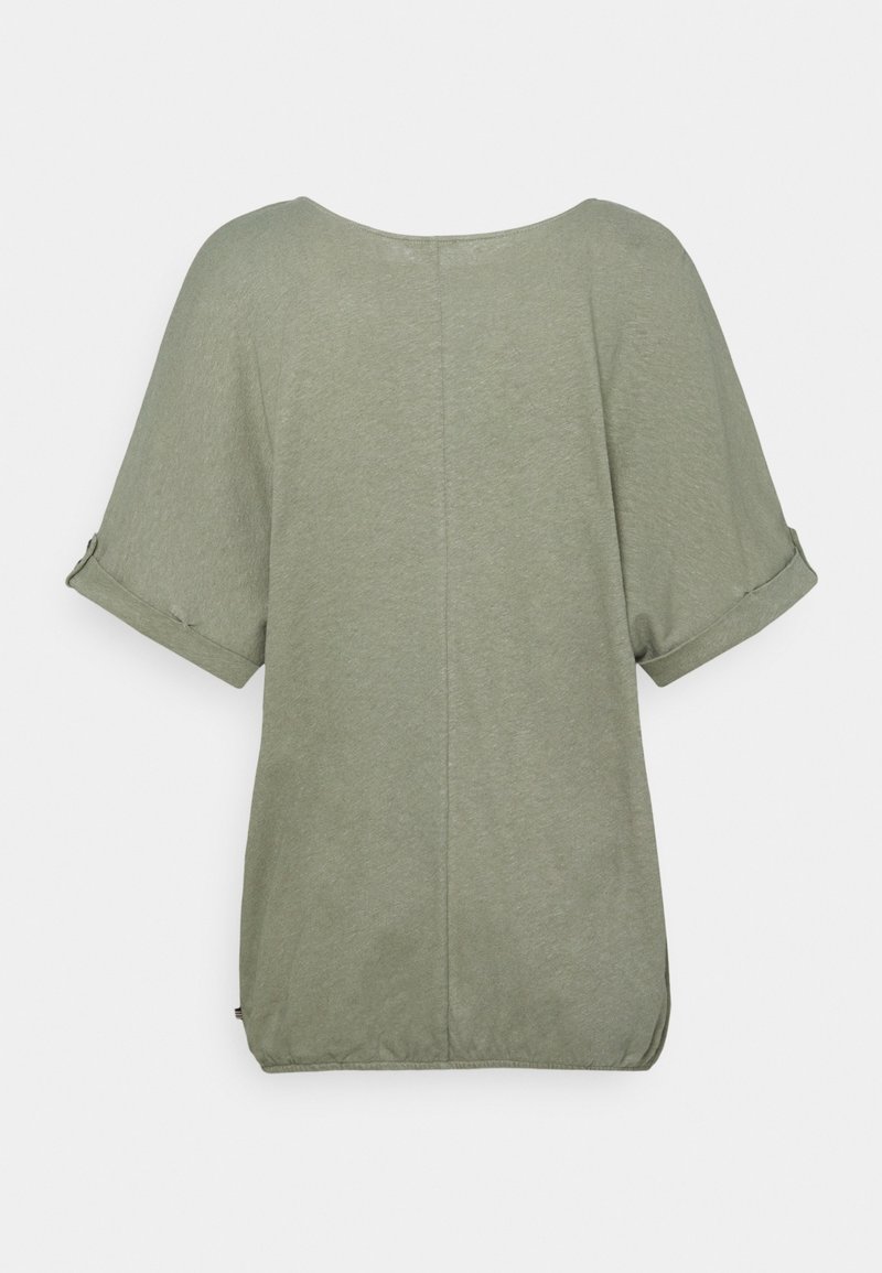 Chemise vert olive clair à manches courtes avec poignets retroussés et une couture centrale, vue de dos sur un fond uni.
