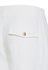 Pantalon blanc avec une seule poche arrière dotée d'un rabat et d'une fermeture par bouton beige, passants de ceinture visibles à la taille.