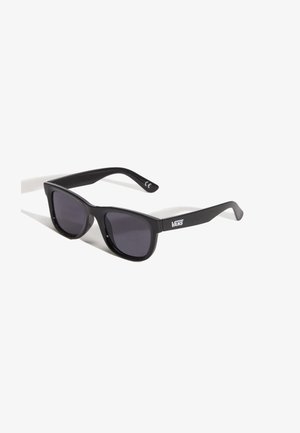 Lunettes de soleil Vans rectangulaires noires avec des verres teintés foncés, légèrement inclinées sur un fond blanc.