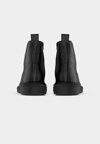 Black leather ankle boots featuring a smooth finish, rounded toe, and side zippers, with a chunky rubber sole for durability.