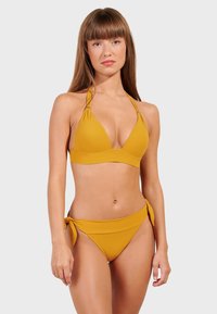Jasne horčicovožlté bikini s trojuholníkovým vrchom s nastaviteľnými ramienkami a spodným dielom so zaviazanými bočnými akcentmi, vyrobené z hladkej látky.