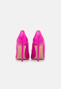 Tacchi alti in pelle laccata fucsia, con punta affilata e sottili tacchi a stiletto, caratterizzati da una texture liscia e lucida.