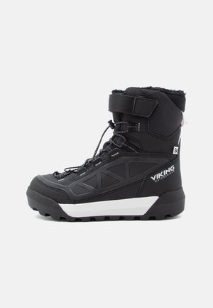 Schwarze wasserdichte Stiefel aus strukturiertem Stoff mit gepolsterter Knöchelpartie, Schnürverschluss und einer weißen Gummisohle mit Griffmustern.