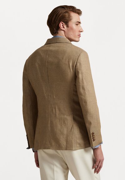  lichtbruine geruite blazer met een getailleerd ontwerp, textuurstof en twee knopen op elke manchet. Tailored achterkant met een iets gestructureerde vorm.