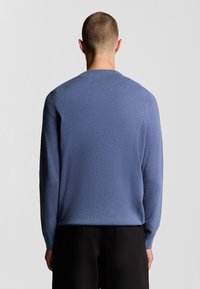 Maglione a girocollo in morbido tessuto blu a maglia testurizzata. Maniche lunghe e vestibilità comoda, con un design pulito e semplice.