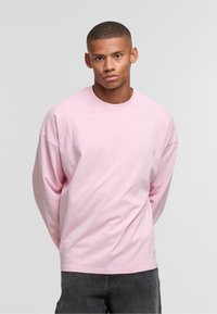 Paarse lange mouwen T-shirt met een ronde hals, ontspannen pasvorm en verlaagde schouders. Gemaakt van zacht katoen, minimalistisch ontwerp zonder patronen.