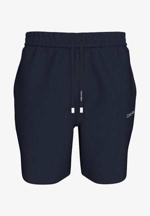 Σκούρο μπλε ανδρικό σορτς Calvin Klein με ελαστική μέση, ρυθμιζόμενα κορδόνια και λογότυπο στην εξωτερική πλευρά του δεξιού ποδιού.