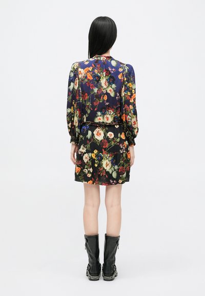 Virágmintás ruha hosszú, puffos ujjal; sötétkék alap; fekete, redőzött szoknya. Combig érő fekete bőrcipővel párosítva.