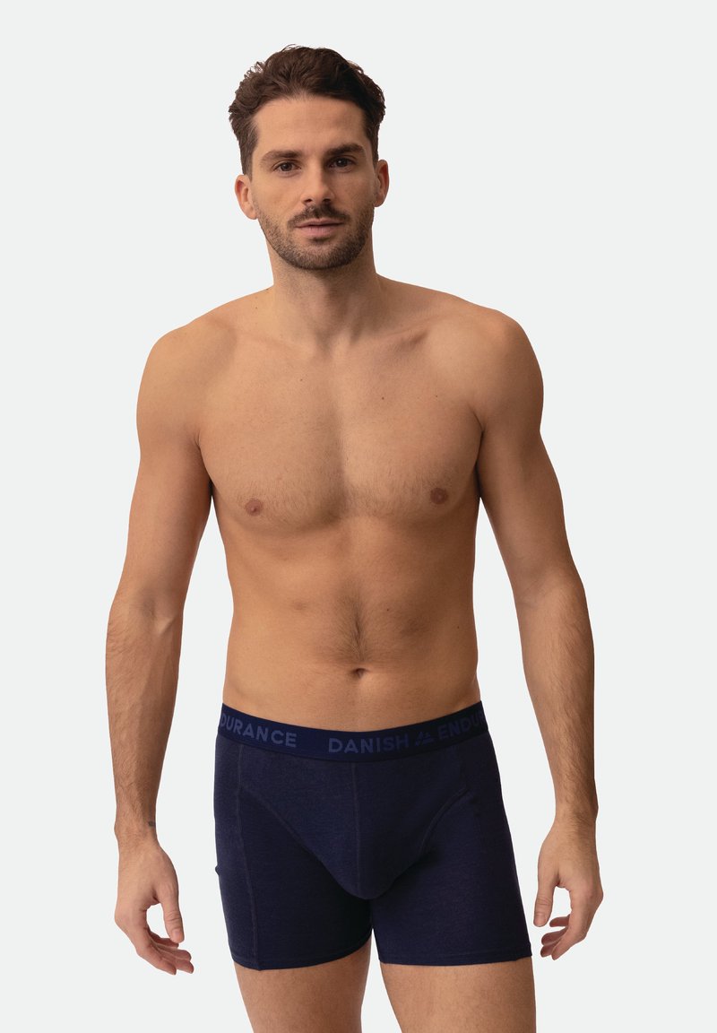 Boxer azul marino con textura suave, cintura contrastante con el texto "DANISH ENDURANCE" y diseño ajustado.