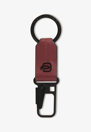 Llavero de cuero con anilla y clip de metal negro, con detalle de costura y un pequeño logo en relieve en la correa de cuero.