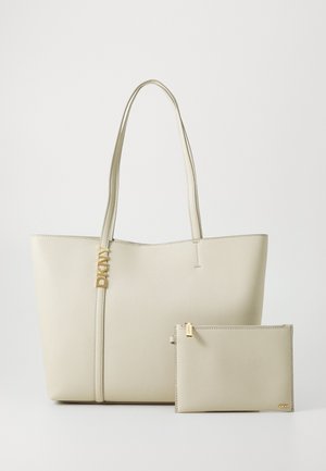 Beige tote bag with smooth faux leather, two long handles, and a gold DKNY logo accent. Includes a matching zippered pouch.