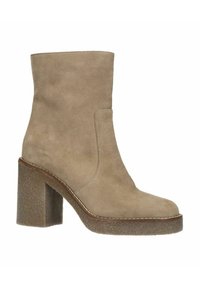 Beige suède enkellaars met een ronde neus, een hoge blokhak en een gestikte detail langs de zool, met een gladde oppervlakte structuur.