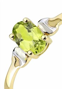 Goldring mit einem facettierten ovalen grünen Edelstein, der von vier Krappen gehalten wird, und silberfarbenen Akzenten an den Seiten des Rings.