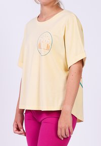Gele katoenen T-shirt met korte mouwen, met een grafische afbeelding van een berg en een beer in oranje en teal, met een relaxte pasvorm en een afgeronde zoom.
