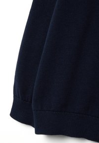 Maglione a maglia blu navy, con orlo arrotondato e polsini a coste. La texture è liscia con un motivo a maglia di peso medio.