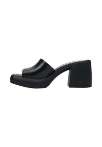 Zwarte heeled mules van soepel leer met een open teen, met een gestructureerde blokhak en een minimalistisch ontwerp.