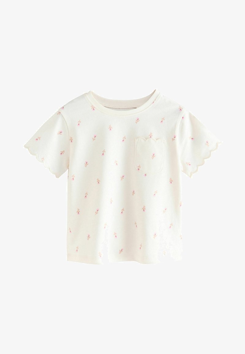 Valge lühikese varrukaga t-särk, millel on laineline äär, kaunistatud hajusate roosa lillede mustritega ja väike laineline tasku vasakul küljel.