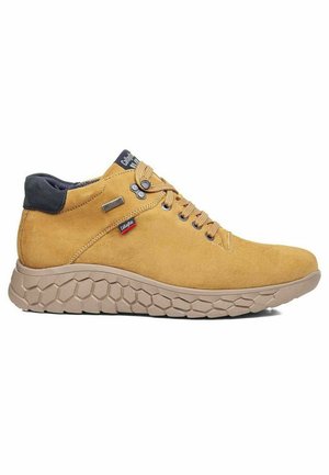 Zapatillas de ante amarillas de caña alta con un cuello acolchado gris oscuro, cordones redondos y una suela de goma beige texturizada con un patrón hexagonal.