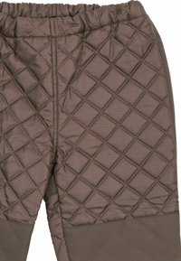 Tissu brun matelassé avec couture en losanges sur un pantalon doté d'une taille élastique et de poignets chevilles marron uni.