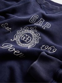 Granatowa bluza z białym haftowanym logo, okrągłym wzorem oraz napisem "GAP" i "Est. 1969" z prążkowanymi mankietami.