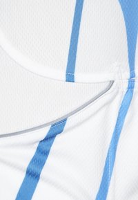 Bílý sportovní top s modrými vertikálními pruhy, texturovanou látkou a hladkým prošíváním kolem zaobřeného výstřihu.