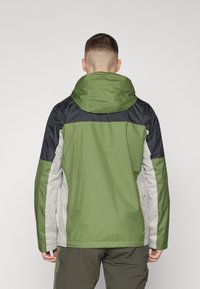 Grøn og sort vandtæt jakke med justerbar hætte, lange ærmer og kontrasterende grå paneler; glat tekstur og praktisk design.