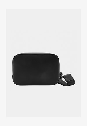 Black rectangular bag made of smooth leather, featuring a zip closure and a removable strap. Simple design with clean edges and minimal detailing.