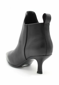 Czarne skórzane botki za kostkę z ostrym noskiem, zakrzywionym obcasem i pętlą z tyłu. Gładka faktura, minimalne detale, elegancki styl.