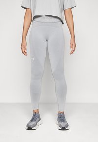 Leggings gris claro fabricados con material elástico, con una cintura alta y paneles texturizados. Equipados con un logo en la parte inferior de la pierna.