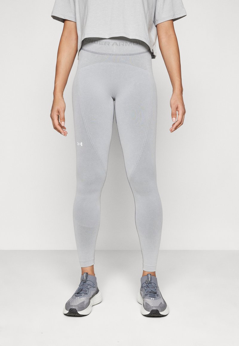 Leggings gris claro fabricados con material elástico, con una cintura alta y paneles texturizados. Equipados con un logo en la parte inferior de la pierna.